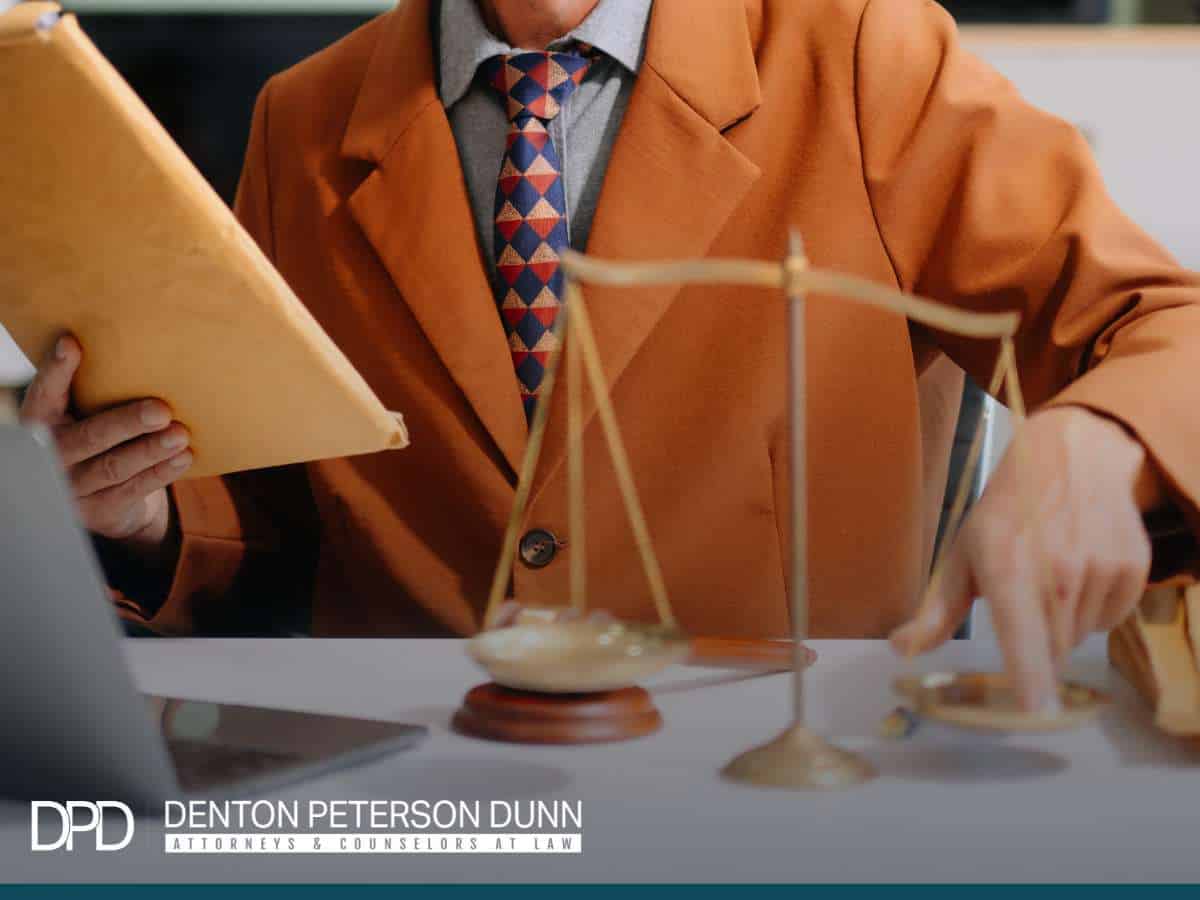 Business attorney reviewing legal documents and scales of justice